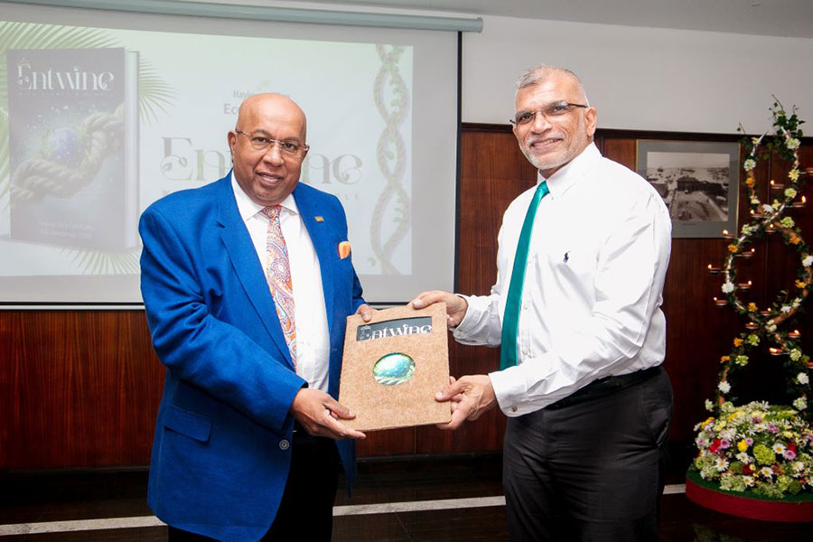 Eco Solutions Managing Director Rajeeve Goonetileke presenting a copy of Entwine to Hayleys Group Chairman and Chief Executive Mohan Pandithage